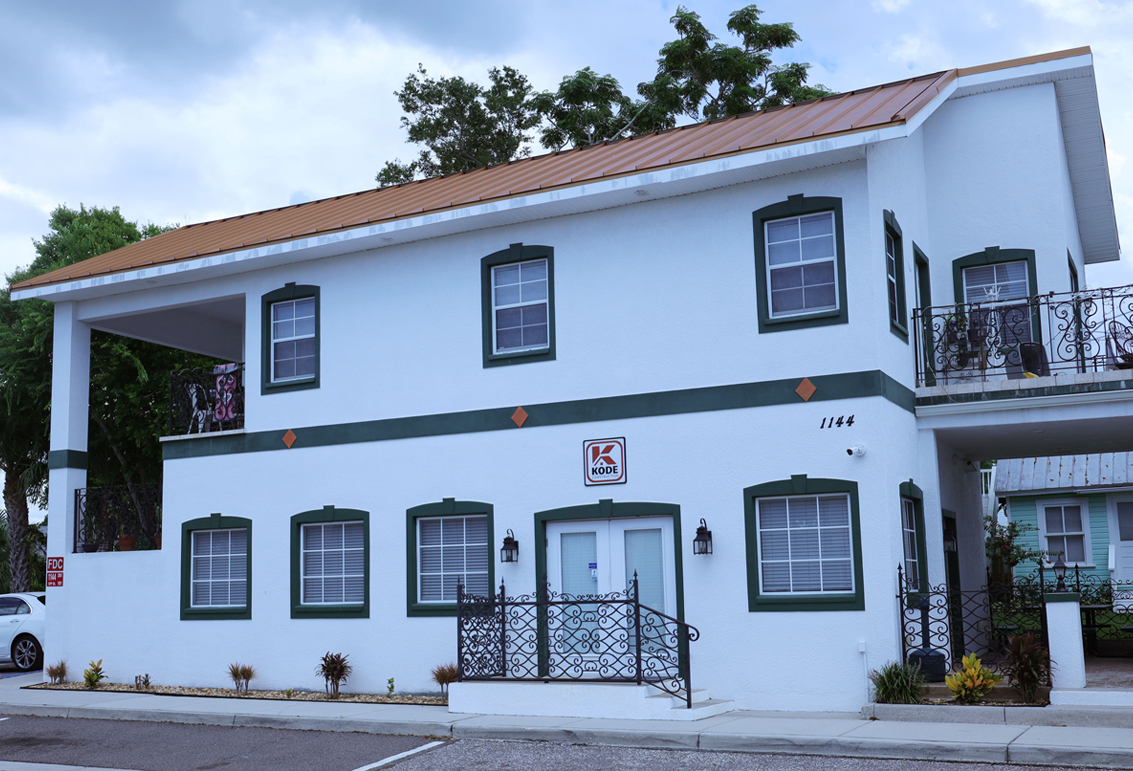 This image is an exterior photograph of a commercial office building located at 1144 12th Street, Palm Harbor Florida